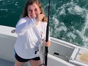Cute young lady angler vacationing in Corolla shows off a spanish mackerel.