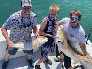 Young anglers showing off the large red drum caught on a Wild Card charter.