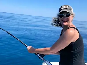 Young lady angler reel in mahi on a charter fishing trip.