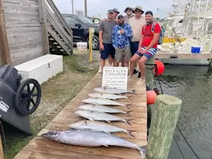 Family group staying in Duck, NC standing with their catch of tuna.