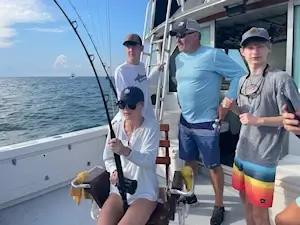 The group vacationing in Manteo watching young lady fighting a tuna.
