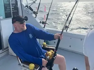 Angler in Wild Card's fighting chair battling large fish.