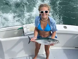 Young lady angler holding fish she caught on near shore charter trip.