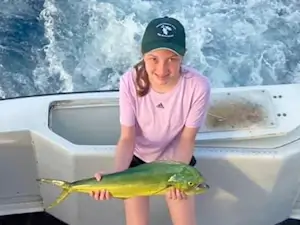Young lady angler showing off her mahi caught on a Wanchese charter trip on Wild Card charters.