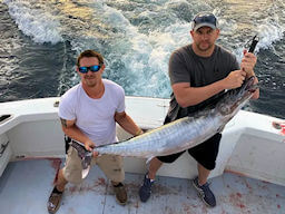 Angler and mate struggle to hold up a very state citation heavy wahoo on a Wild Card offshore charter.