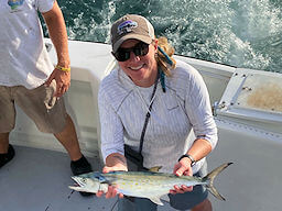 Pretty young lady angler holding one of several nice spanish mackerel she caught on a near shore charter trip.