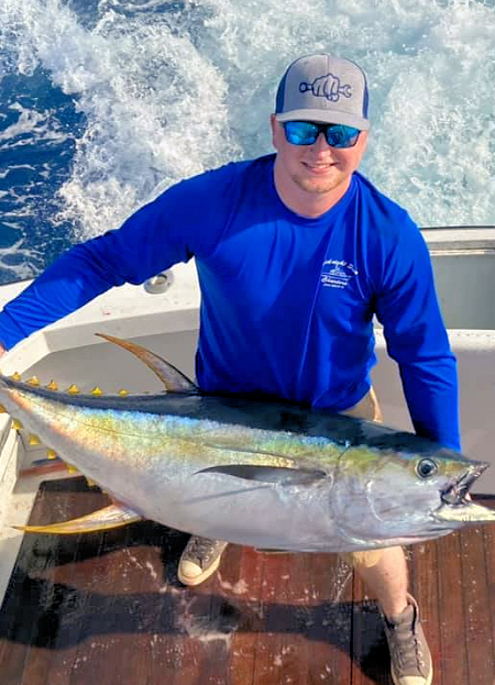 Angler holding large yellowfin tuna.