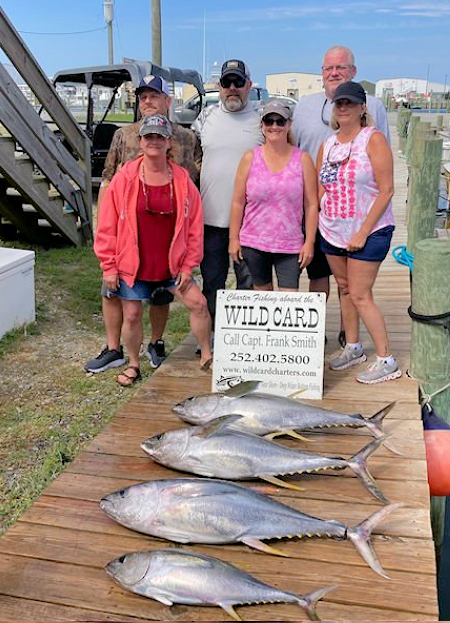 Family showing off catch of tuna.